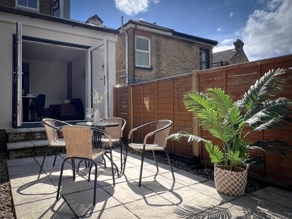 een patio met stoelen, een tafel en een plant bij Campbells Crib in Kent