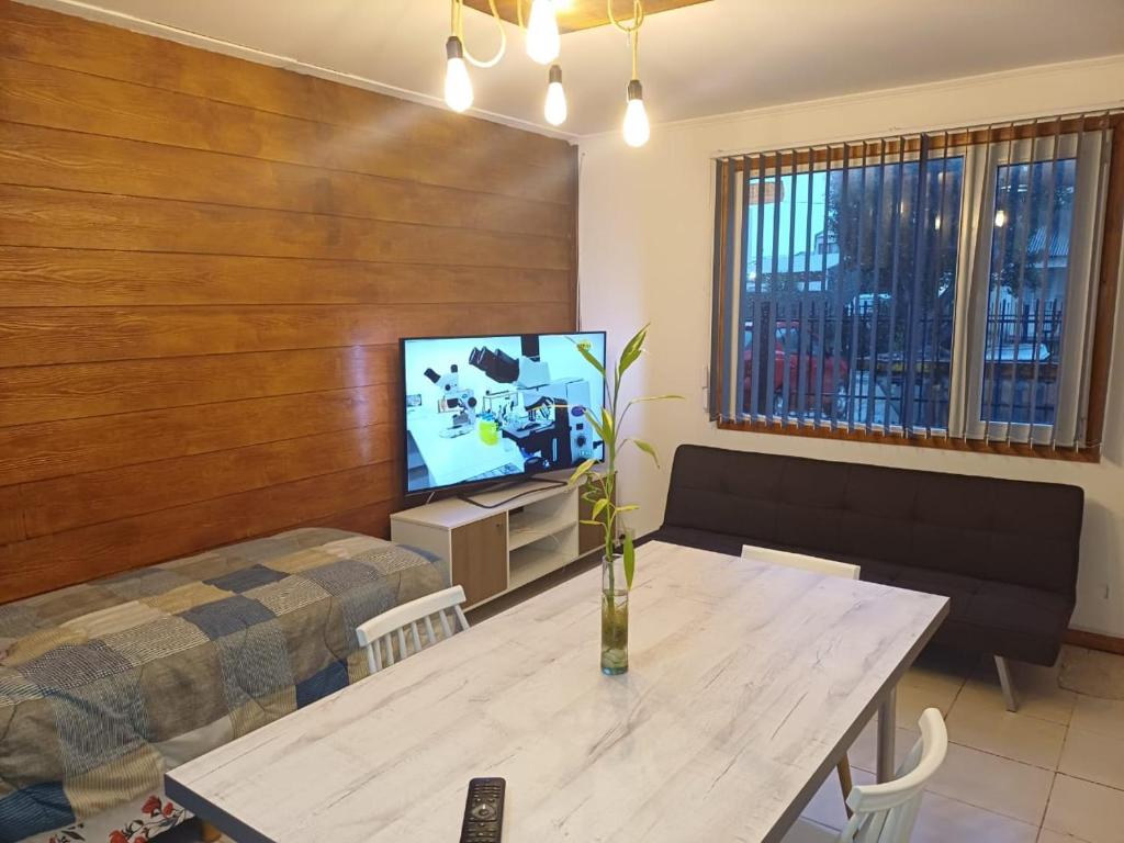 sala de estar con mesa y TV en Departamento Temporario Rio Grande en Río Grande