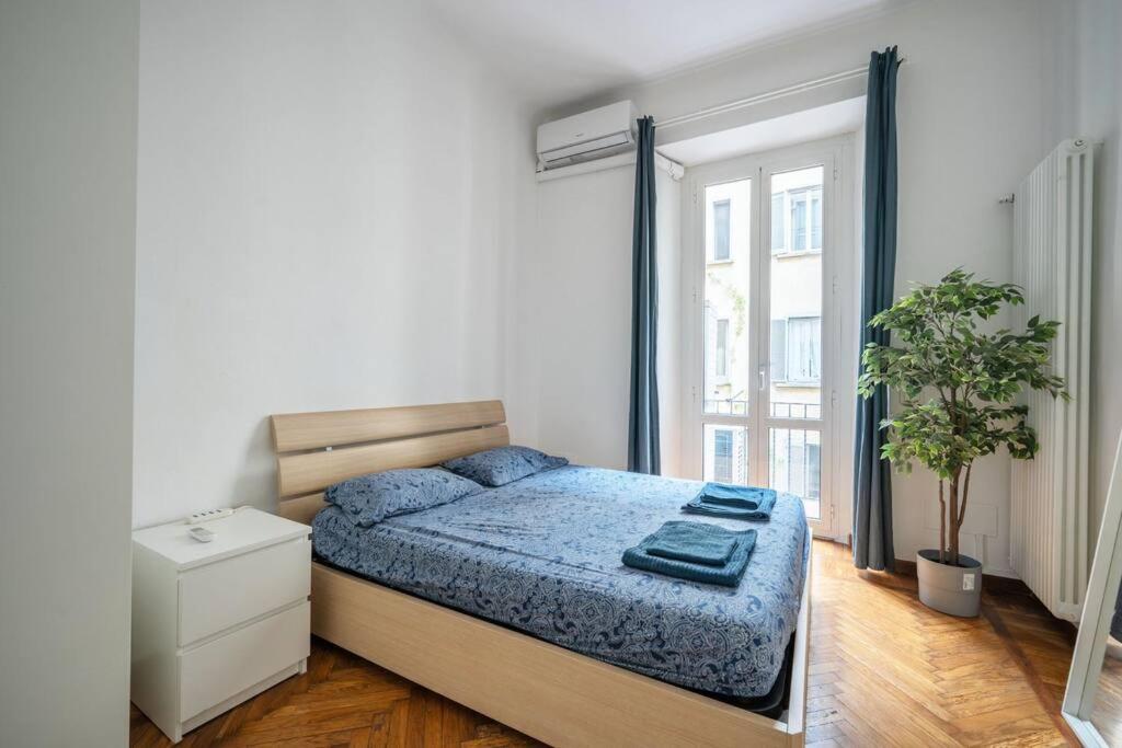 Un dormitorio con una cama y una ventana grande. en Nice apartment in Milan Porta Venezia Duomo, en Milán