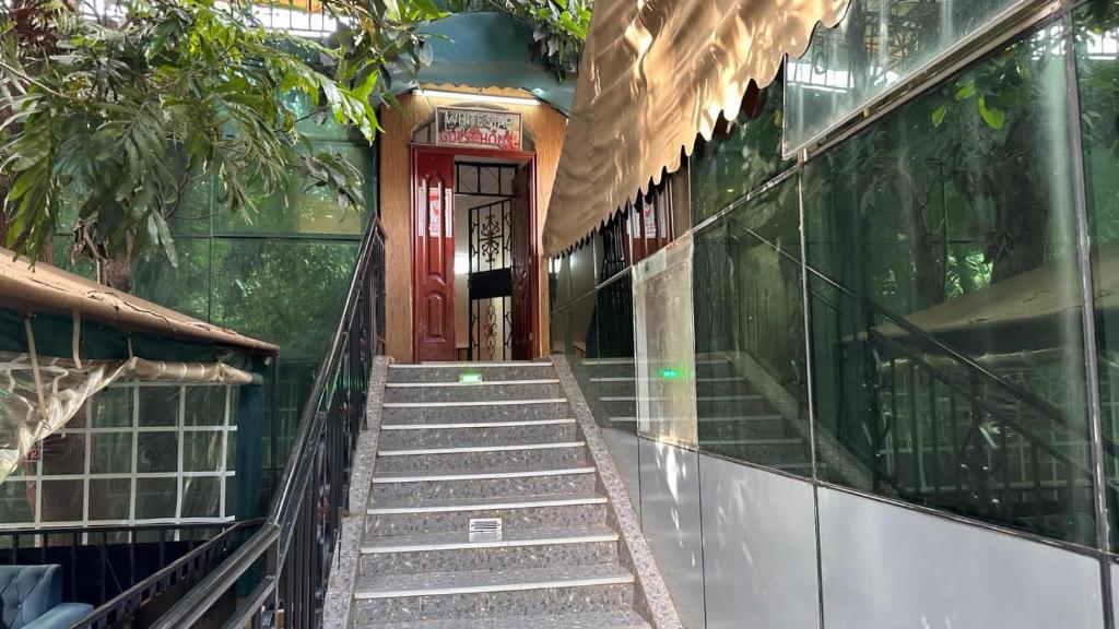 eine Treppe, die zu einem Gebäude mit einer roten Tür führt in der Unterkunft White Star Hotel in Nairobi