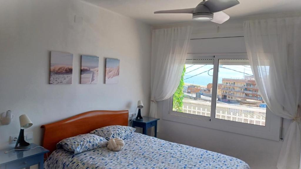 Canet playa y centro في كانيه دي مار: غرفة نوم بسرير ونافذة كبيرة