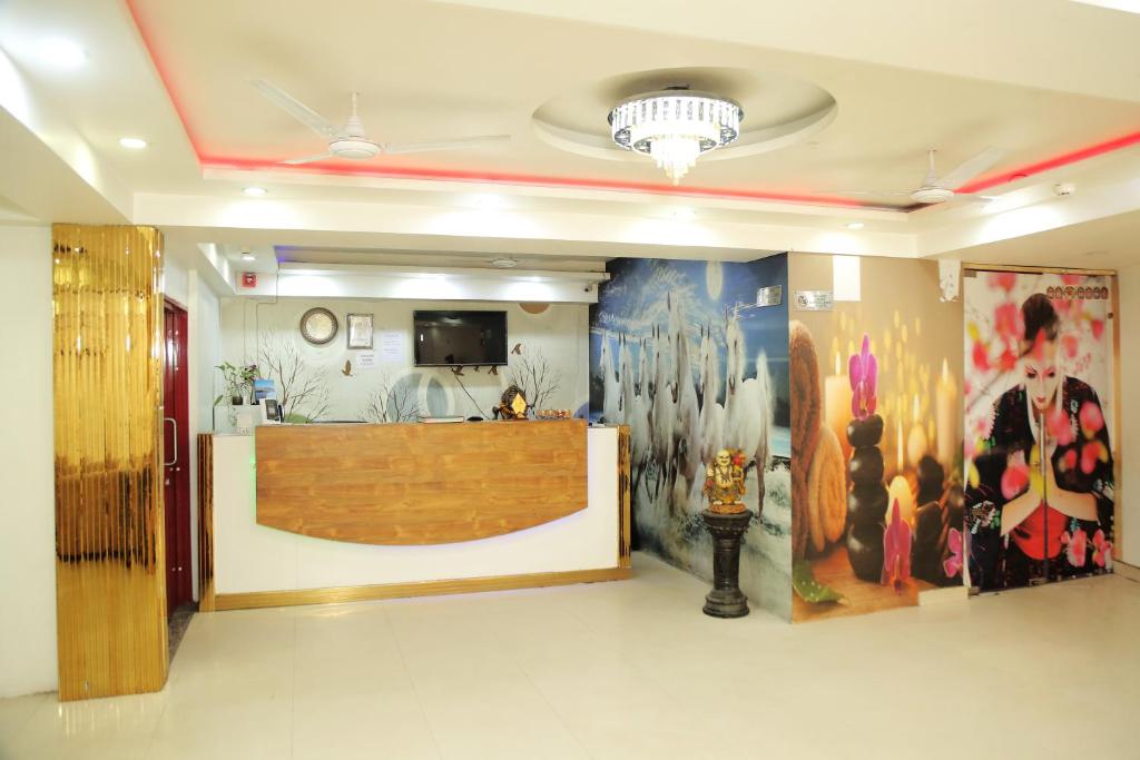 Hotel Aman Inn With early check in في نيودلهي: لوبي به لوحات على الجدران ومكتب استقبال