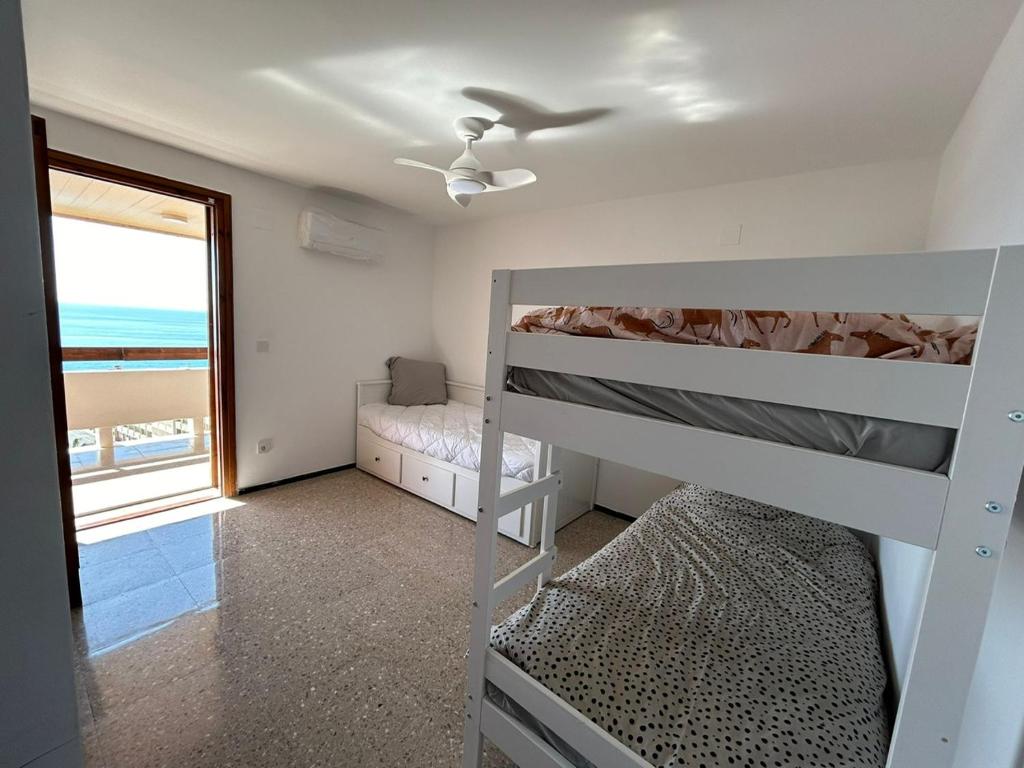 a bedroom with two bunk beds and a window at la casa de Adela - Cala lanuza in El Campello