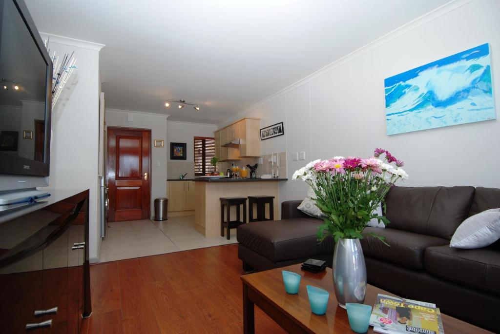 a living room with a couch and a vase of flowers on a table at 13 Bella Rosa Apartment in Durbanville