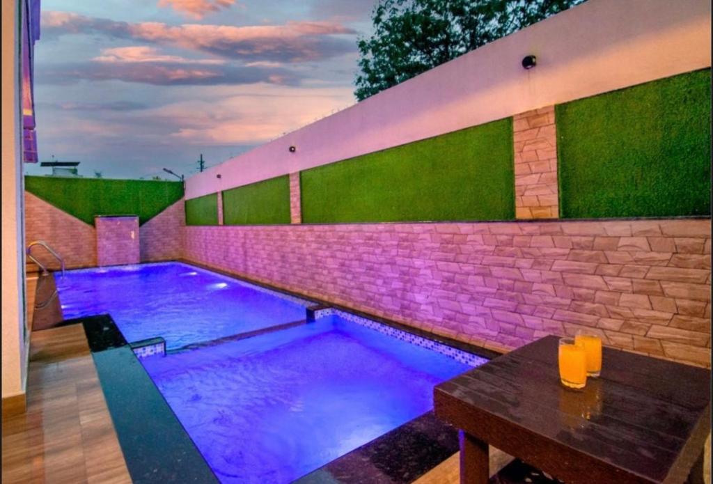 una piscina con iluminación púrpura en un patio trasero en LAUGHTALE VILLA 4Bhk Swimming Pool, en Lonavala