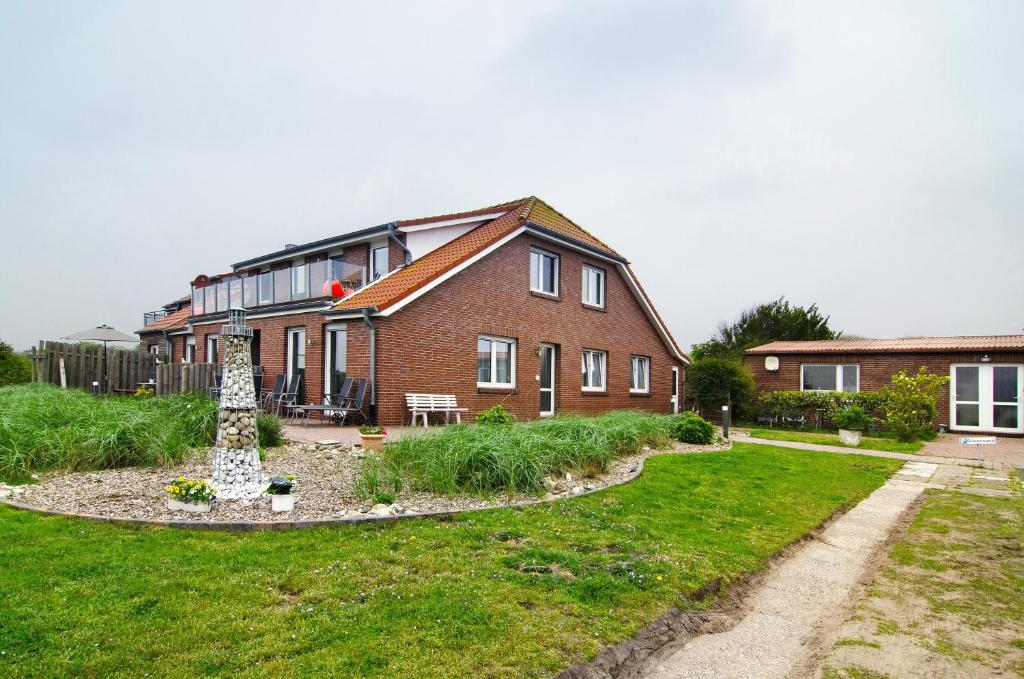 a brick house with a garden in front of it at Opashus in Borkum