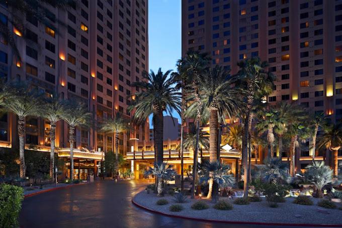 a courtyard with palm trees in front of a building at Hilton Grand Vacation Club The Boulevard in Las Vegas