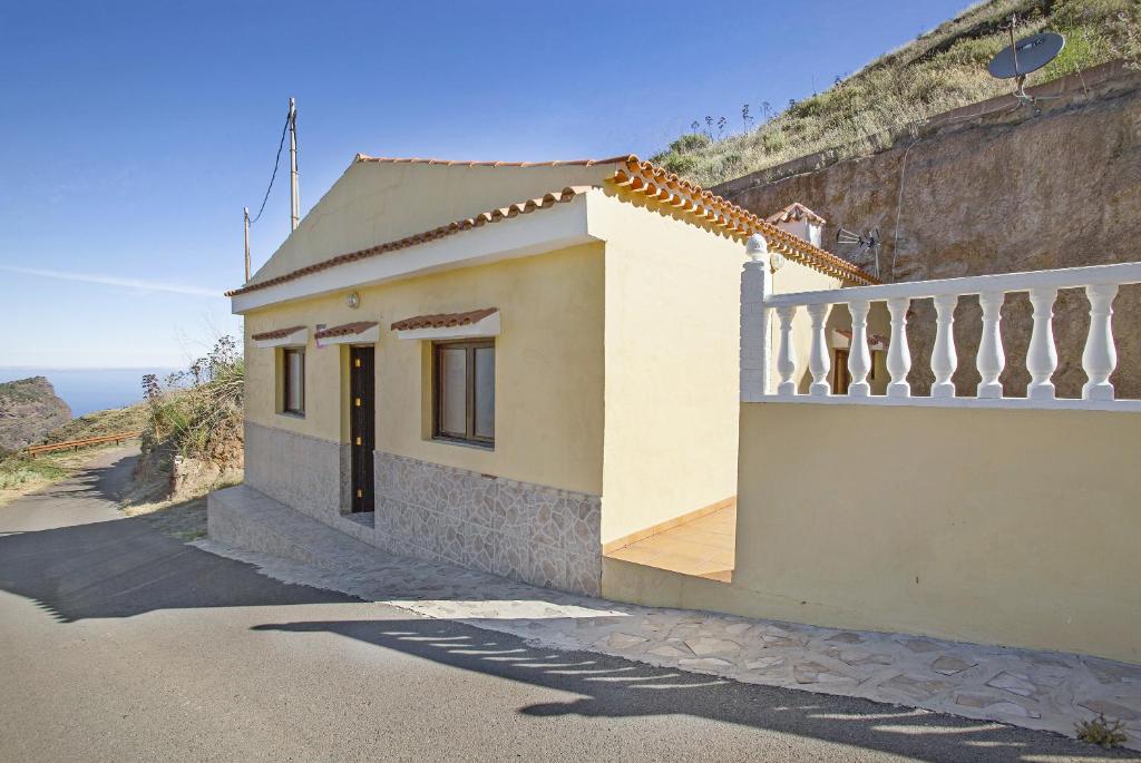 une petite maison sur le côté d'une montagne dans l'établissement Villa Palomino, à Gáldar