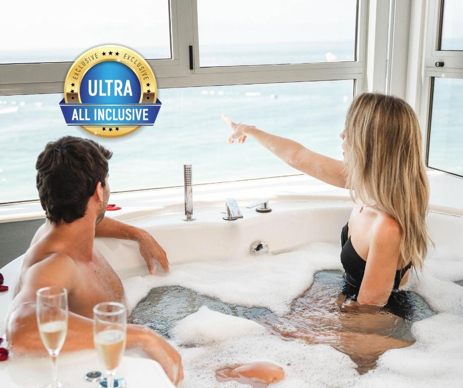 a man and a woman sitting in a bathtub at Hotel Villa del Mar in Benidorm