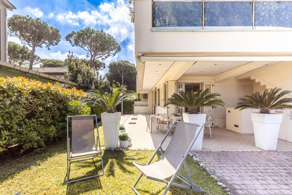 una casa con sillas y plantas en el patio en [Cervia - 100 mt dal mare ] Villetta con giardino privato e parcheggio, en Cervia