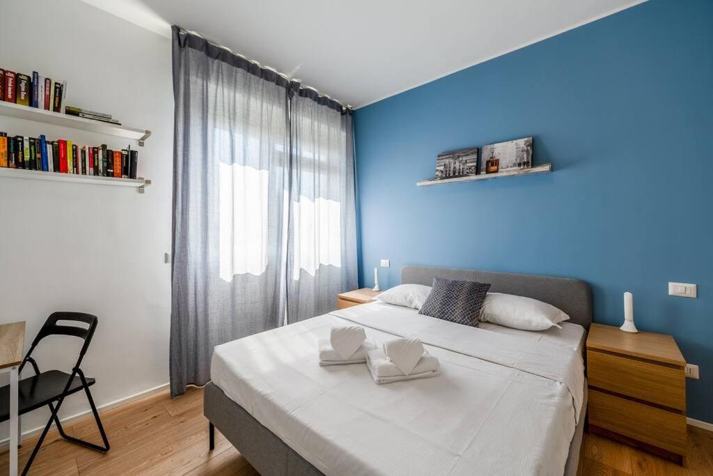 ein Schlafzimmer mit einem großen Bett mit einer blauen Wand in der Unterkunft Ospedale Niguarda - Moderno Appartamento a Milano by Hôtea in Mailand