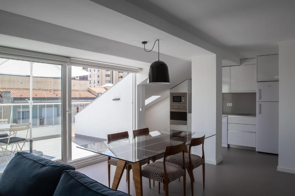 An open-plan apartment living and dining area beside a compact kitchen.