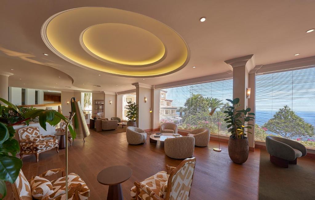 a large living room with a large yellow ceiling at The Cliff Bay - PortoBay in Funchal