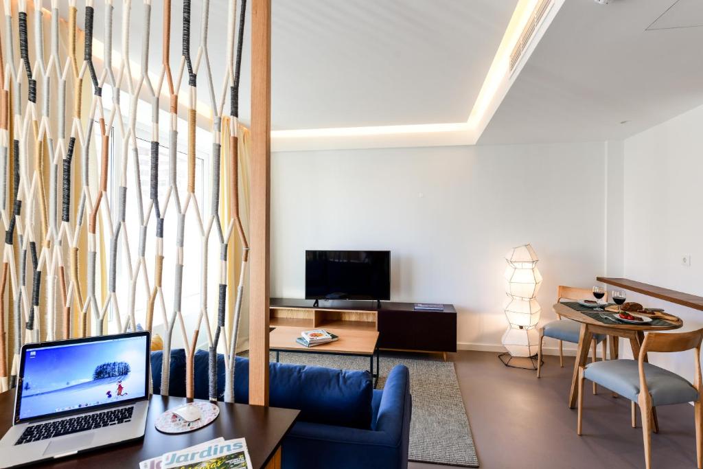 A laptop sits on a compact desk overlooking the apartment’s lounge and dining area.