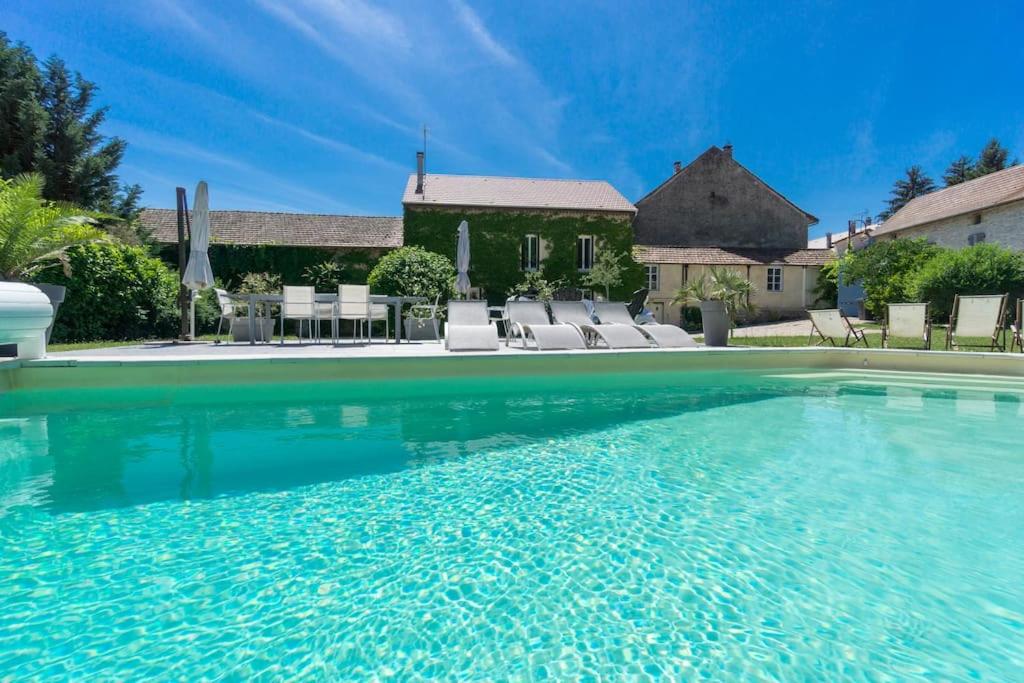 ein großer Pool mit blauem Wasser vor einem Haus in der Unterkunft Gite de charme Le Clos Michel 14 personnes piscine in Briord