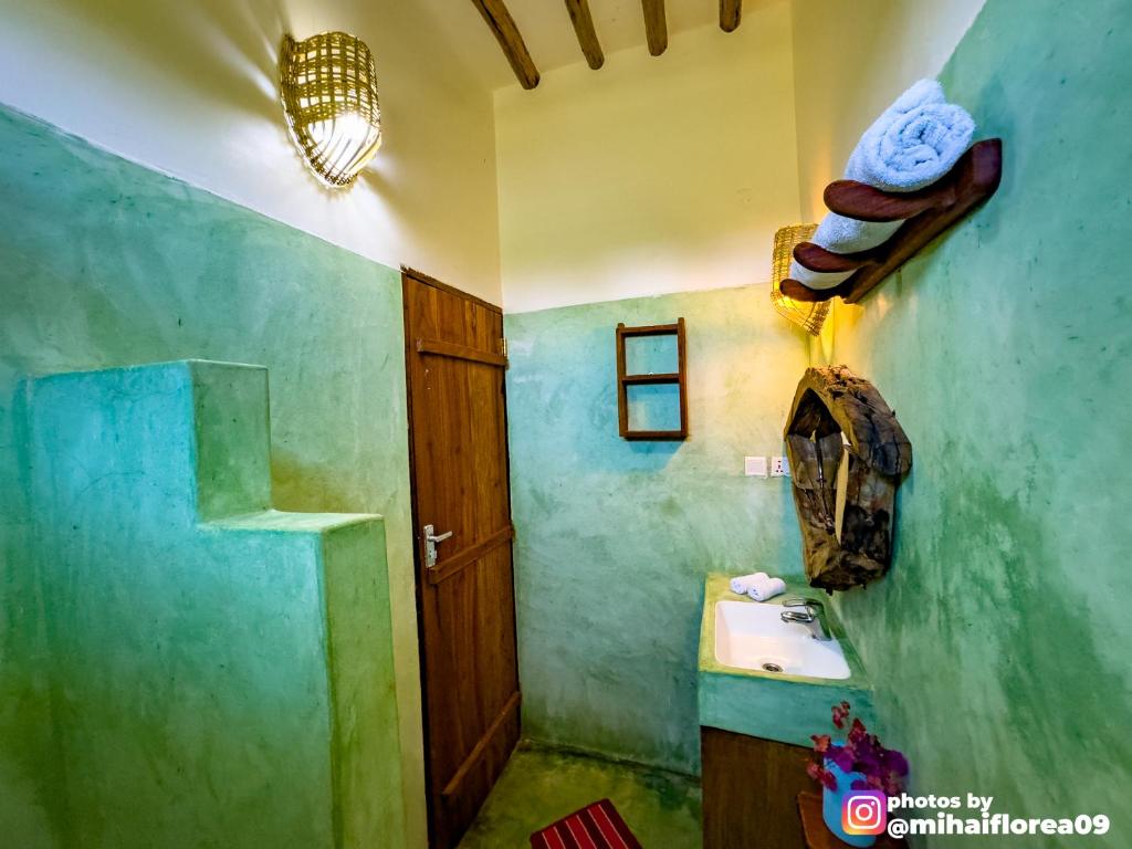 a bathroom with a sink and a toilet in it at Tofauti Inn in Makunduchi