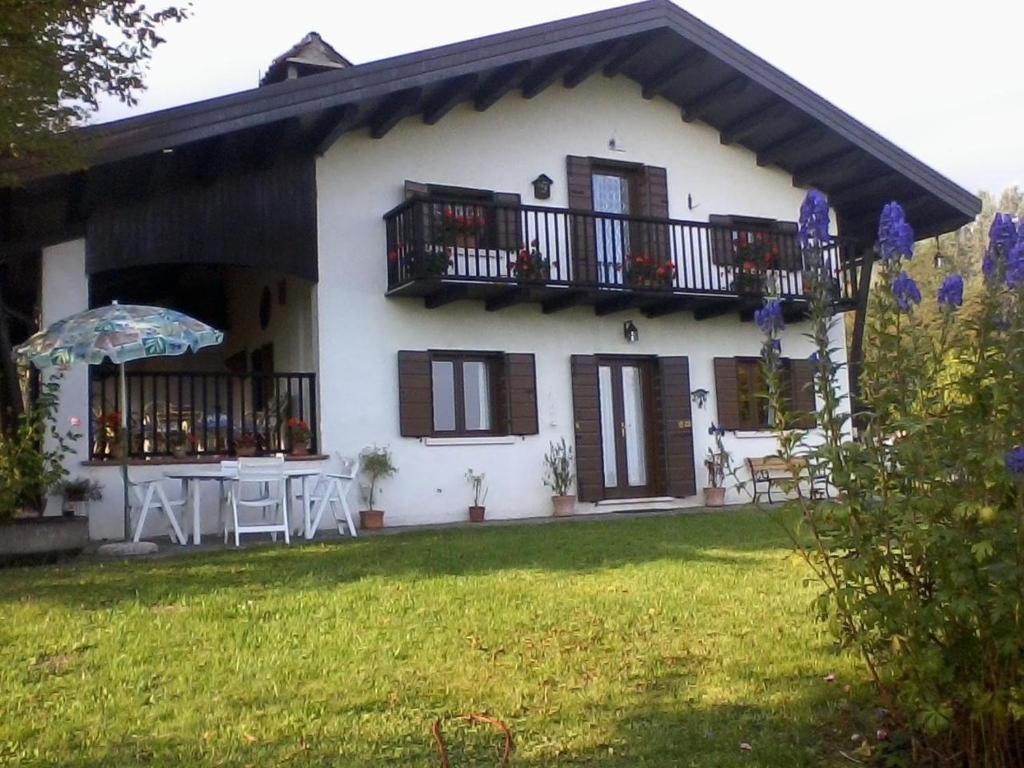 uma casa branca com uma mesa e uma varanda em Schönes Ferienhaus in San Gregorio Nelle Alpi mit Grill und Terrasse em San Gregorio nelle Aloi