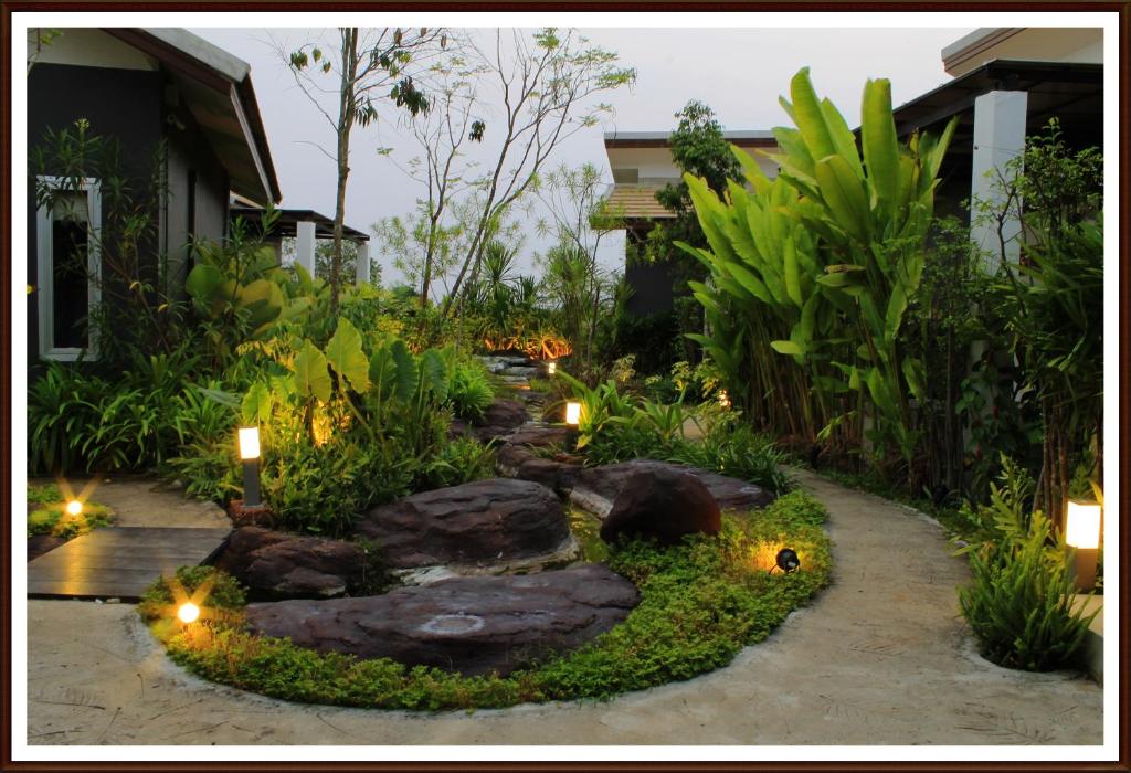 einen Garten mit Felsen und Lichtern vor einem Haus in der Unterkunft Saabpaiboon Grand Resort in Ban Talat