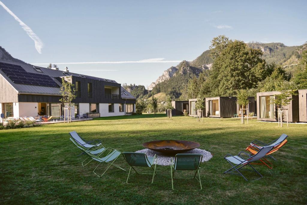 un grupo de sillas y una mesa en un patio en The Campus Alps - tiny homes, en Hieflau