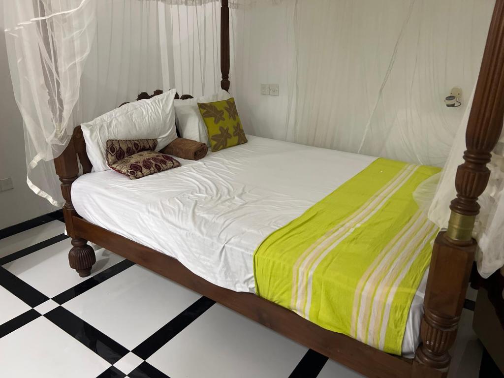 a bedroom with a bed with a green and white comforter at Dirty Beach Villa by Dolce in Matara