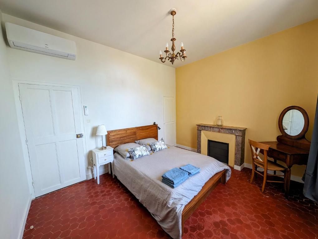 a bedroom with a bed and a desk and a mirror at Maison de style tout confort, position idéale, avec clim et petit extérieur in Orange