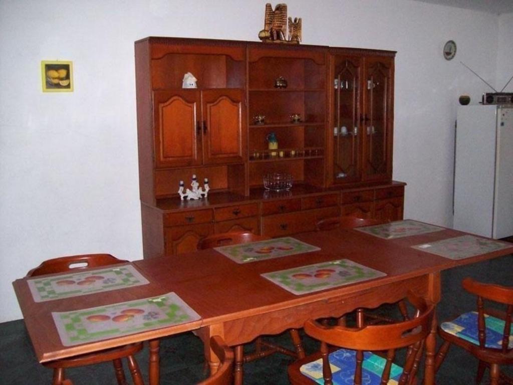 uma mesa de jantar com cadeiras e um armário de madeira em Ferienhaus in Balatonfkajár mit Grill, Garten und Terrasse em Balatonfőkajár