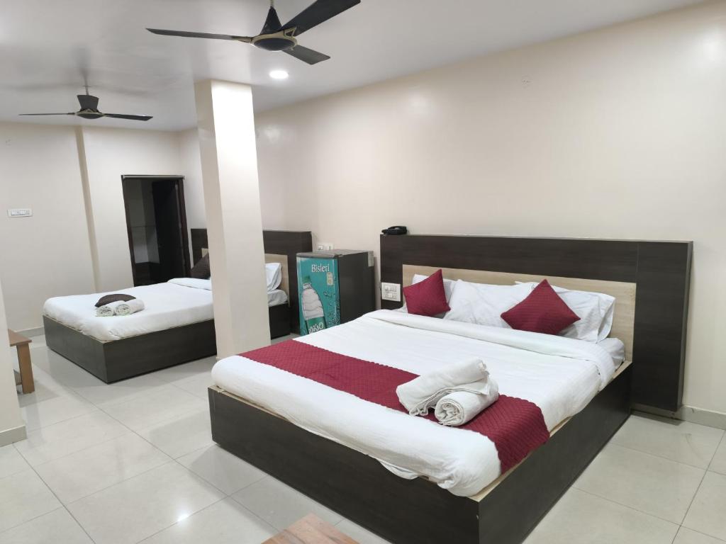 ヴィシャカパトナムにあるarchana GRANDのベッドルーム1室(ベッド2台、シーリングファン付)