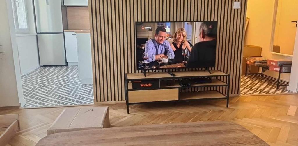 a flat screen tv on a stand in a living room at Apartmán Petzvalova 51 in Myslava