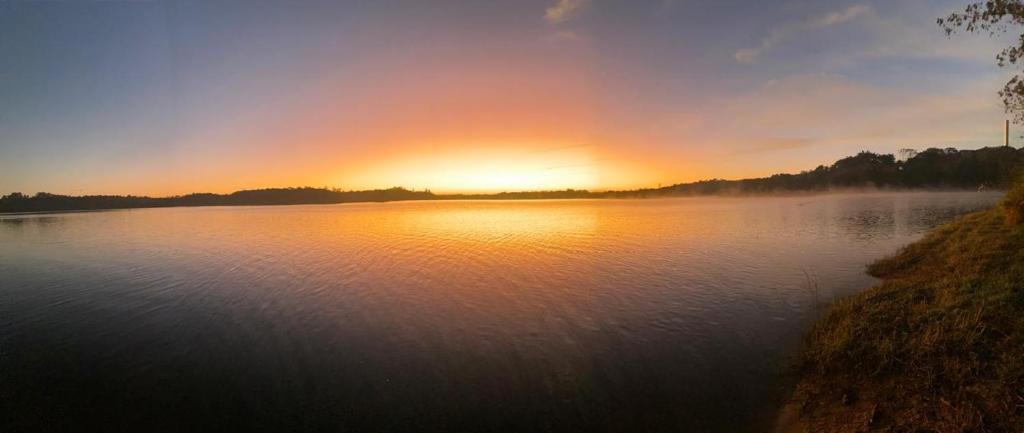 vistas a un lago con puesta de sol en Pousada Guarapiranga en São Paulo