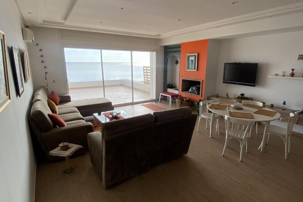een woonkamer met een bank en een tafel bij Dar Douja / Grandview Waterfront Duplex / Four seasons in Sfax