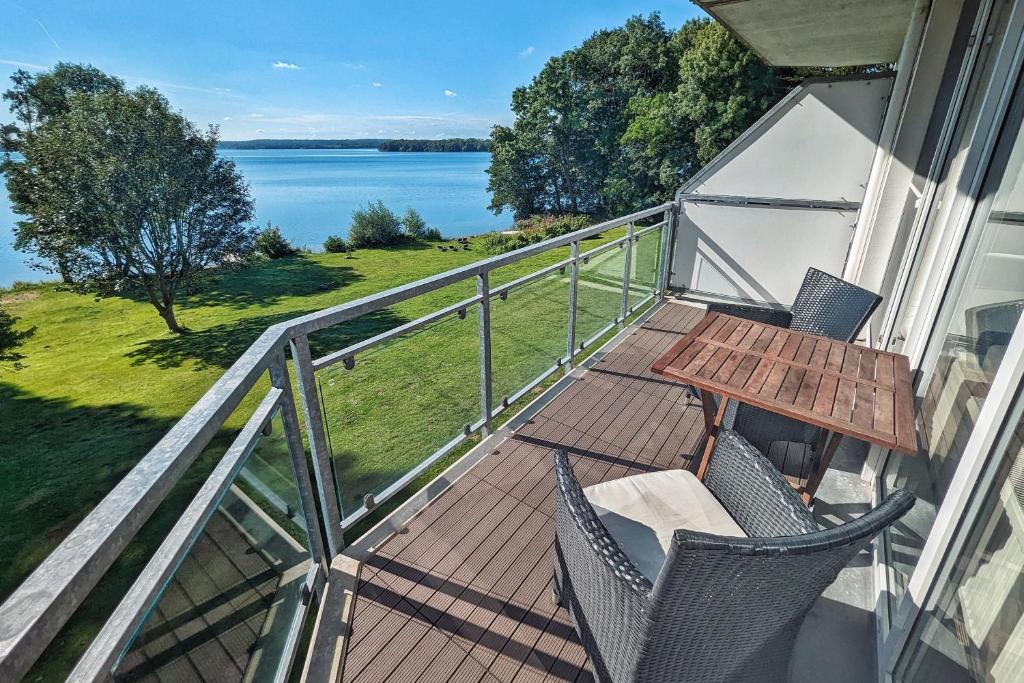 een balkon met een tafel en stoelen en uitzicht op het water bij Junior-Suite am See in Ascheberg