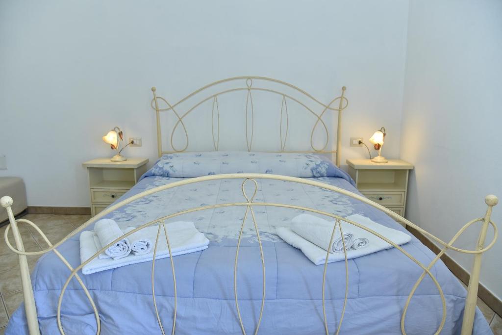 um quarto com uma cama azul com duas mesas de cabeceira em B&B Perdalonga em Ghilarza