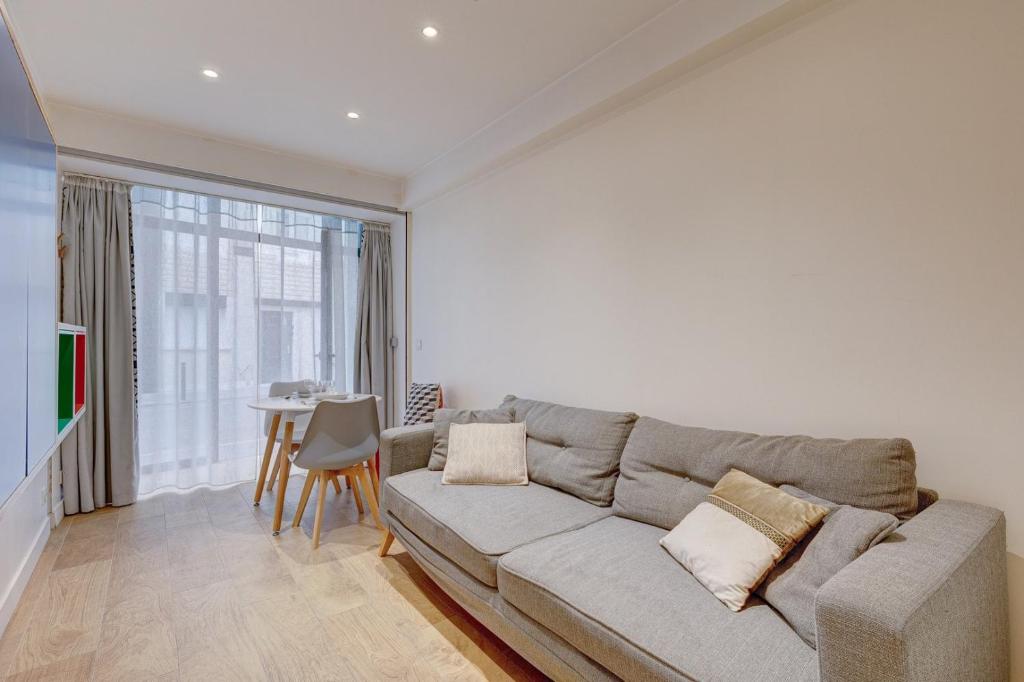 salon z kanapą i stołem w obiekcie 296 Suite Ponceau - Superb apartment in Paris w Paryżu