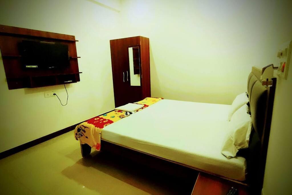 a bedroom with a bed and a flat screen tv at Champaran Home Deluxe in Varanasi