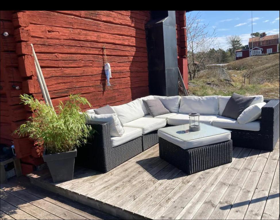 un sofá blanco sentado en una terraza de madera en Cabin retreat in the archipelago, en Djurhamn