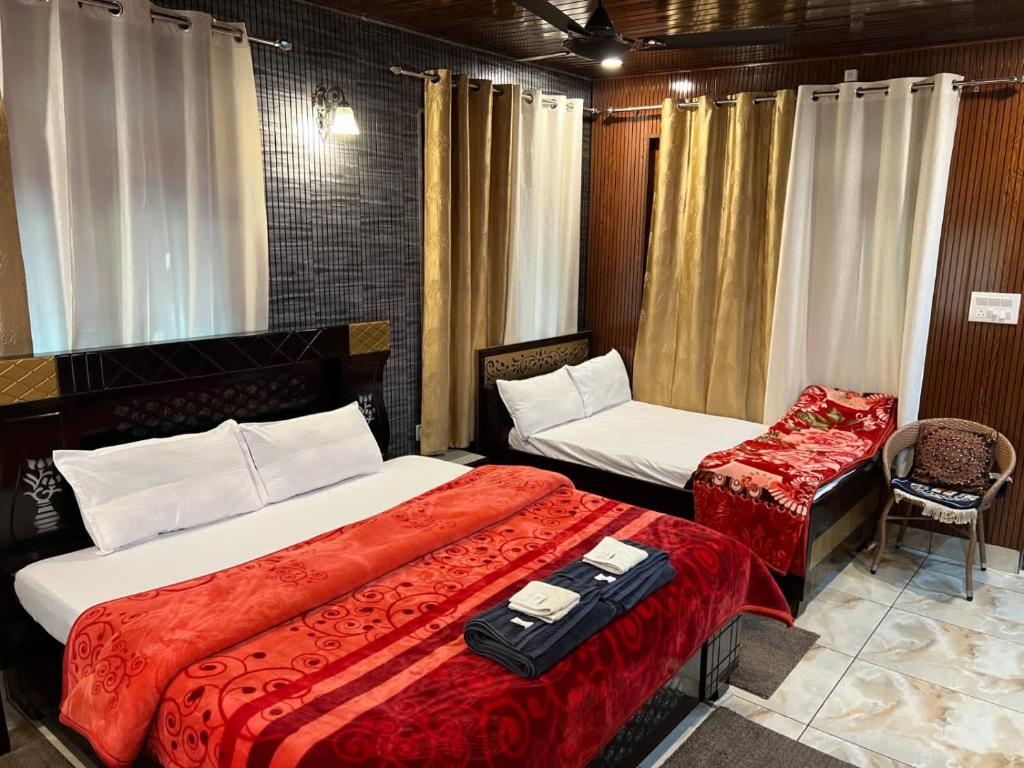 a hotel room with two beds and a chair at Gayatri Niwas - Luxury Private room with Ensuit Bathroom - Lake View and Mountain View in Nainital