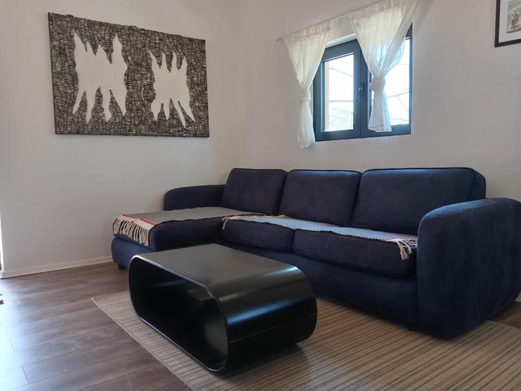 コラシンにあるMountain Mosaic Apartmentsのリビングルーム(青いソファ、黒いスツール付)
