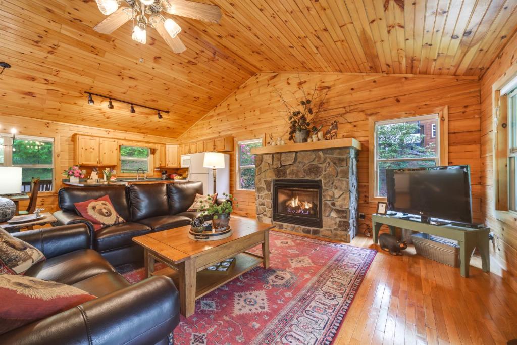 ein Wohnzimmer mit einem Sofa und einem Kamin in der Unterkunft Peaceful Smoky Mountain Cabin with Deck and Fire Pit! in Waynesville