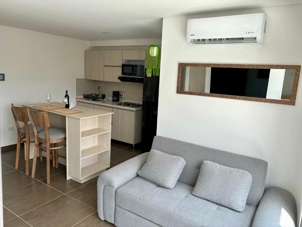 a living room with a couch and a table and a kitchen at Apartamento en Zima con aire acondicionado in Pereira