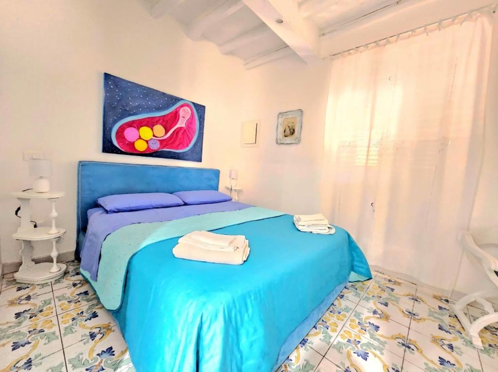 a bedroom with two beds and a painting on the wall at Casa Tina indipendente a 2 passi dal centro al foro italico e al nuovo porto marina bay in Palermo