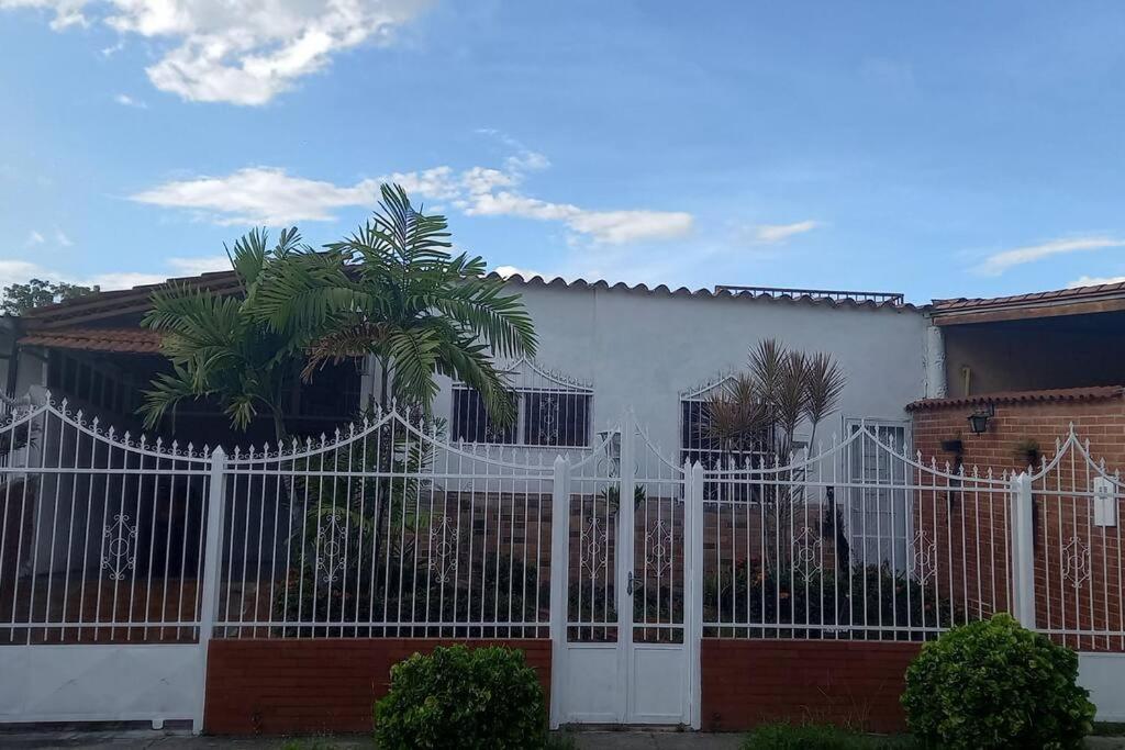 una cerca blanca frente a una casa en Casa-Quinta c-lindo Amb Familiar, en Valencia