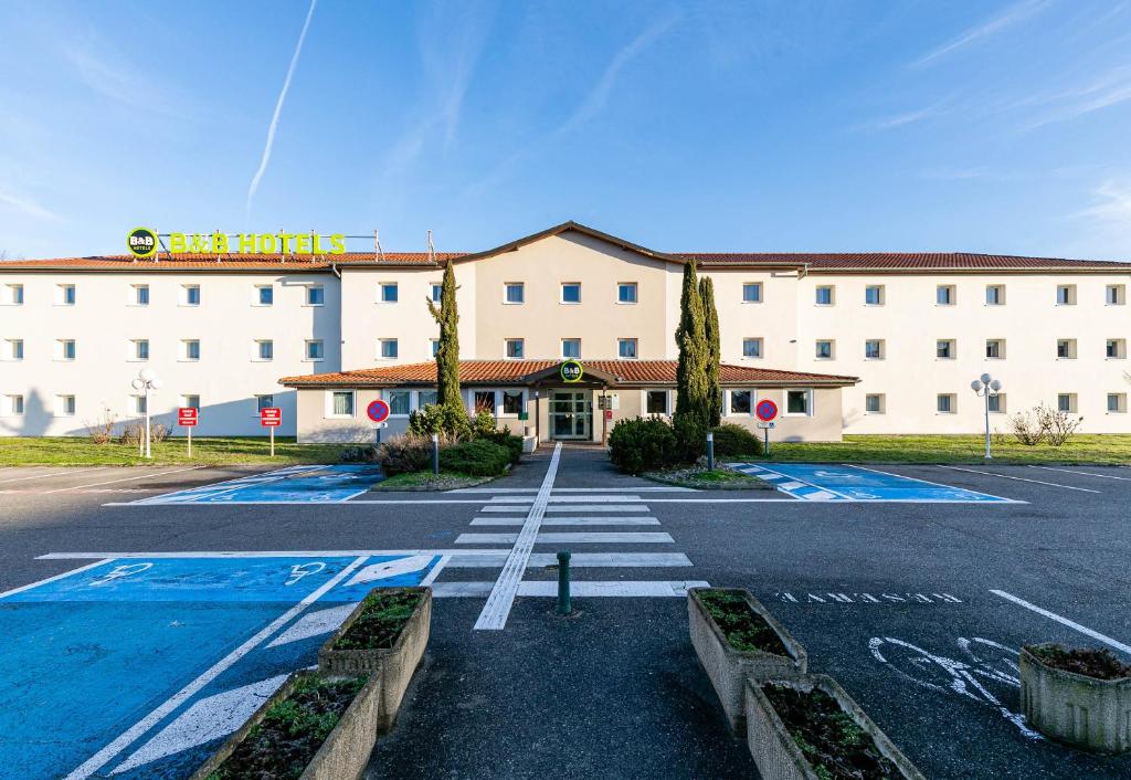 un parking vide en face d'un hôtel dans l'établissement B&B HOTEL Colmar Lumière, à Colmar