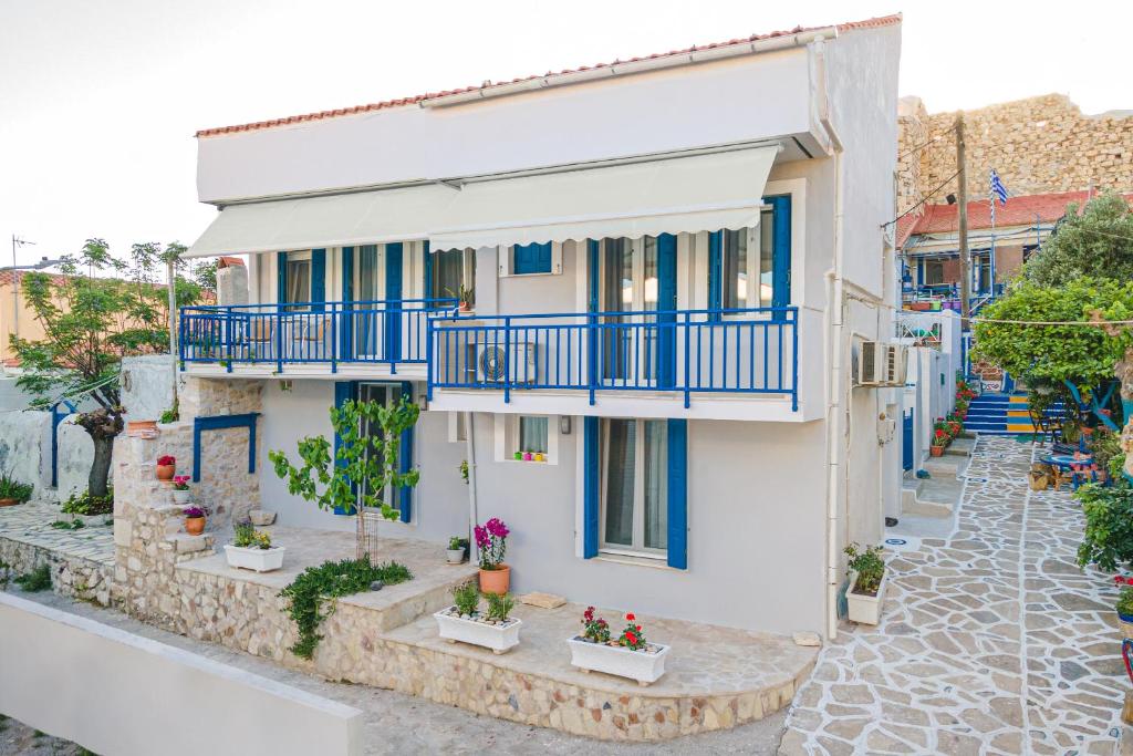 una casa con balcones azules y flores en una calle en Pythagorio Blue Street Apartment with Balcony, en Pythagoreio