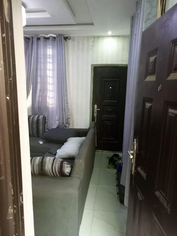 Habitación pequeña con sofá y ventana en House 7 en Lagos