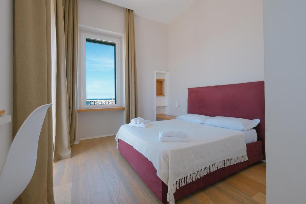 a bedroom with a bed and a large window at La Finestrella in Bari