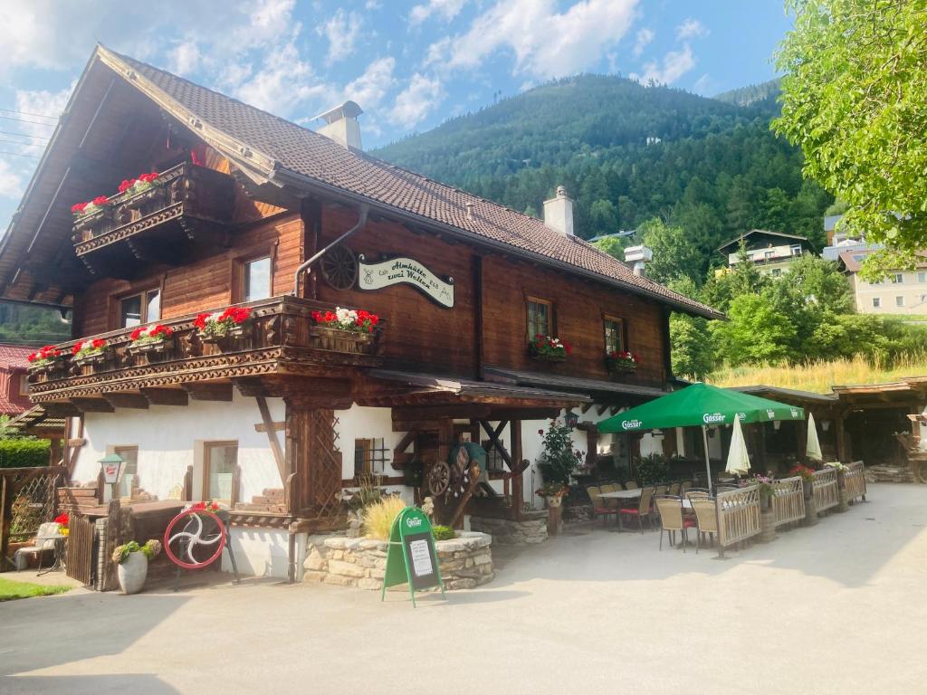 a wooden house with flowers in front of it at Almhütte zwei Welten in Obervellach