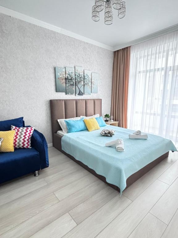 1 dormitorio con 1 cama grande y 1 sofá en ЖК ALPAMYS, en Astana