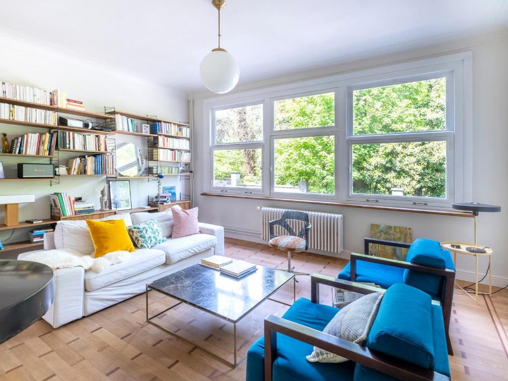 sala de estar con sofá blanco y sillas azules en Brussels Garden House - 4 bdrs, en Bruselas