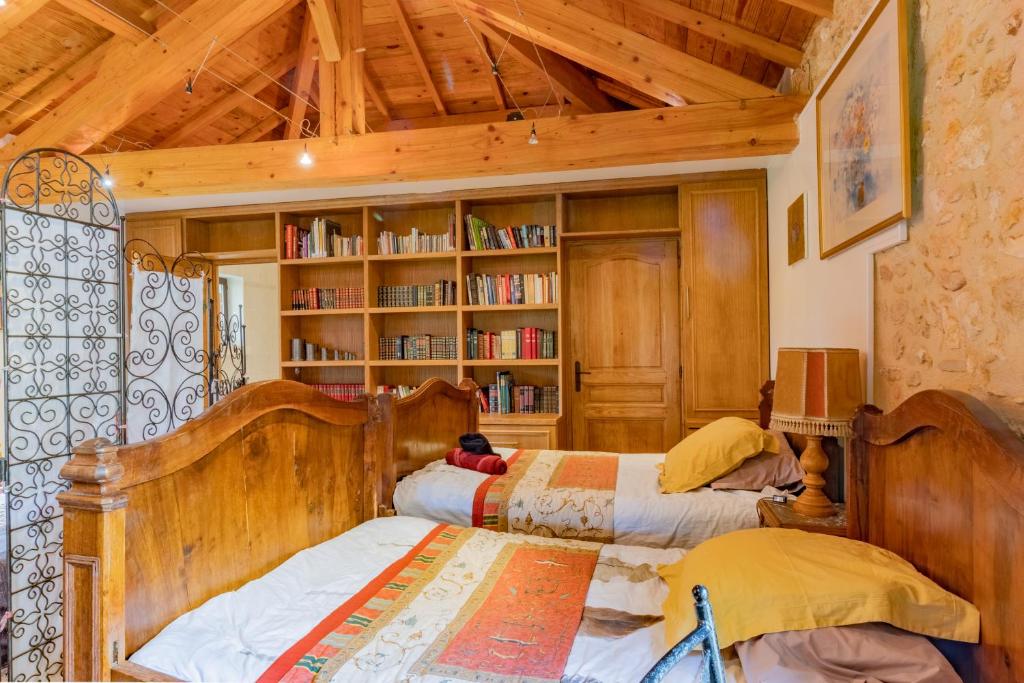 a bedroom with two beds and a book shelf at Gîtes et chambres croix du sud in Saint-Amand-de-Vergt