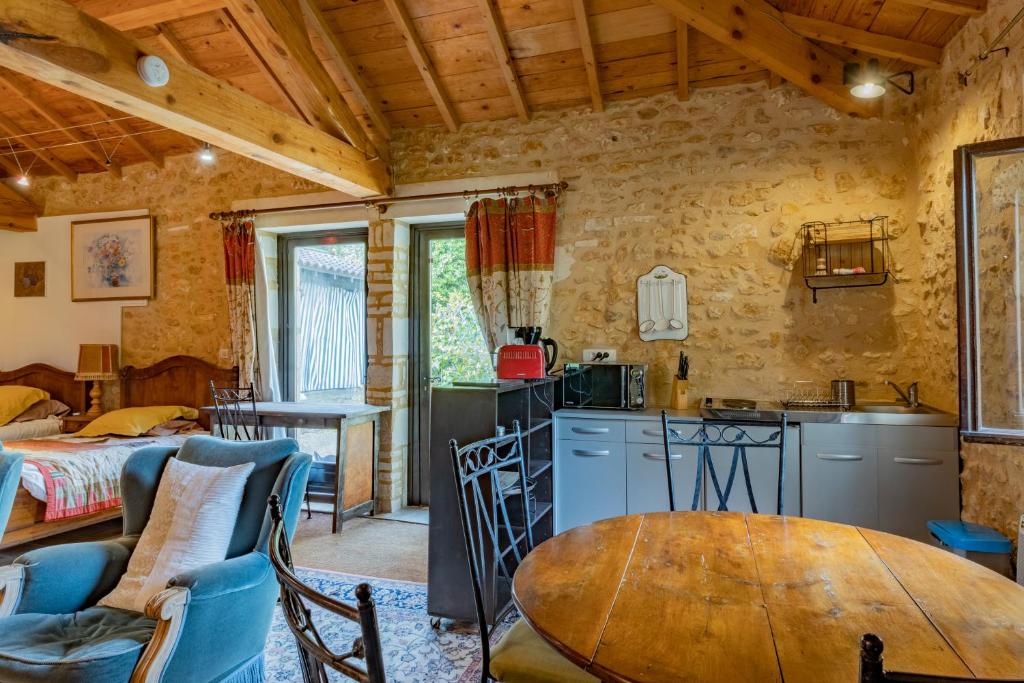 a kitchen and dining room with a table in a room at Gîtes et chambres croix du sud in Saint-Amand-de-Vergt